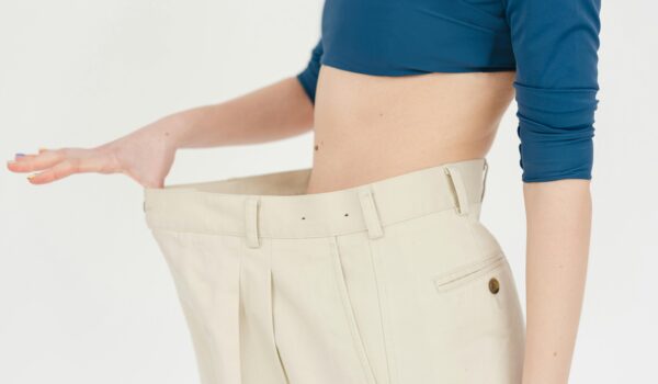 woman holding pants showing weight loss