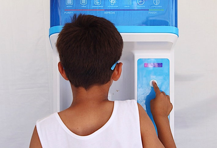 young boy using a FloWater refill station