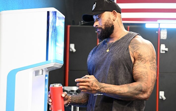 muscular man refilling water bottle with FloWater Refill Station