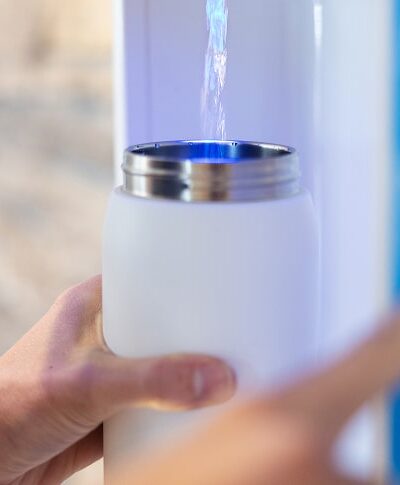 white water bottle being refilled with flowater