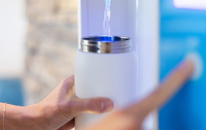 white water bottle being refilled with flowater