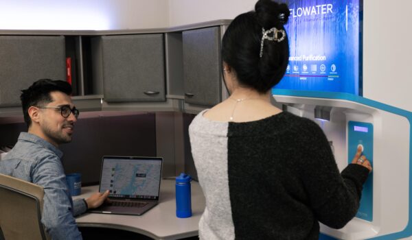 man and woman using FloWater refill station at an office