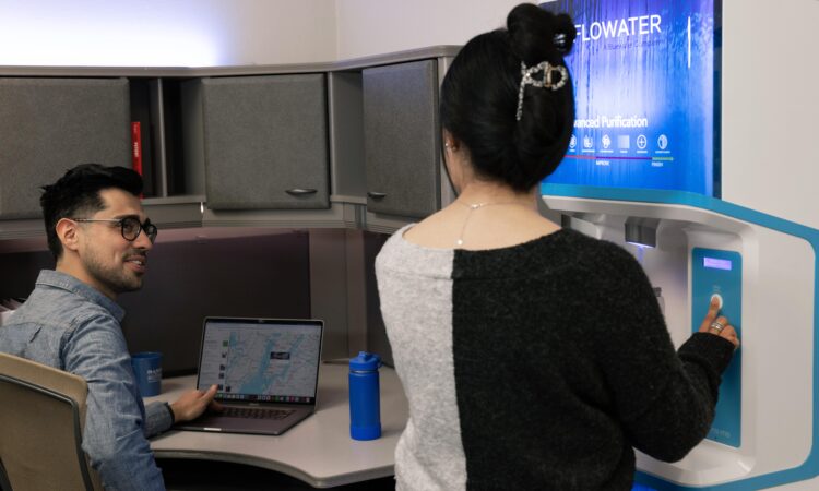 man and woman using FloWater refill station at an office