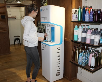 woman in white hoodie using refill station