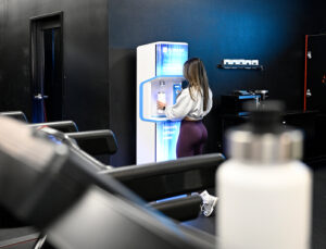 distant shot of woman at gym using flowater refill station