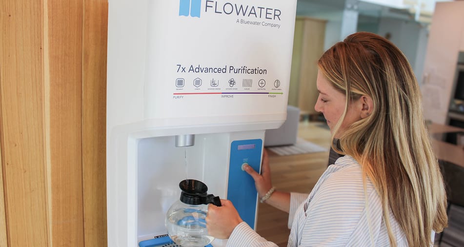 woman refilling coffee container with Flowater refill station