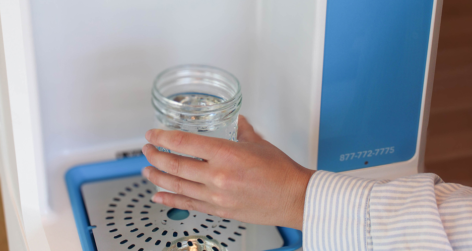 woman refilling a cup of water with the flowater refill station