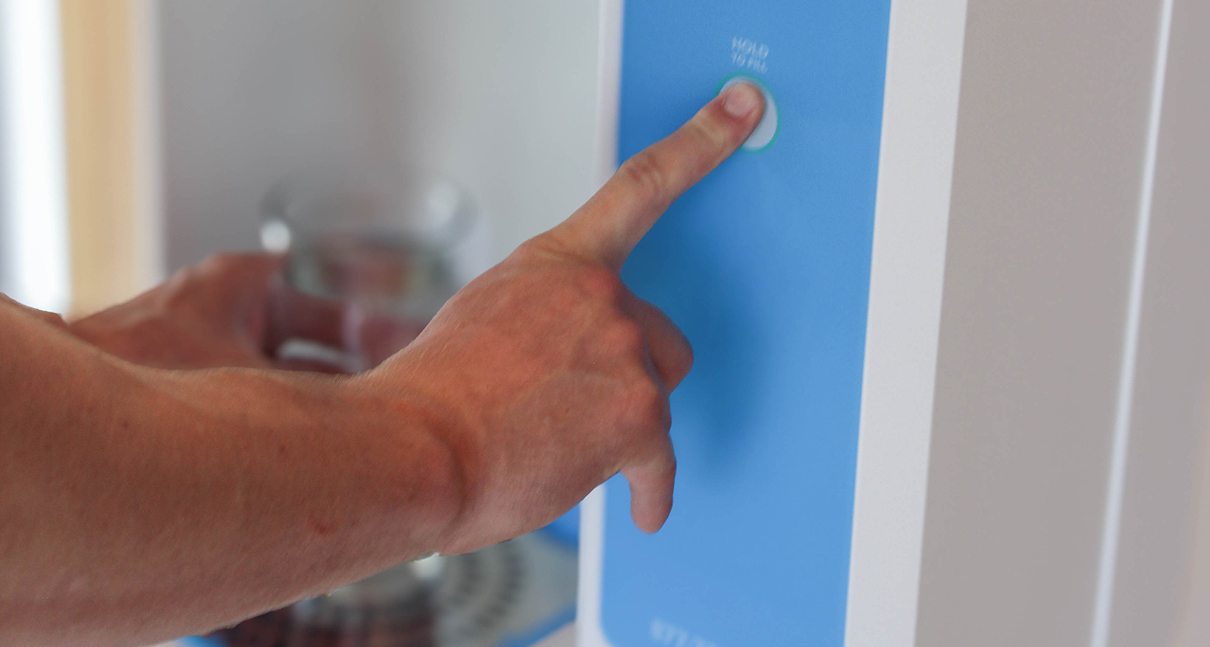 finger pressing the button of a flowater refill station